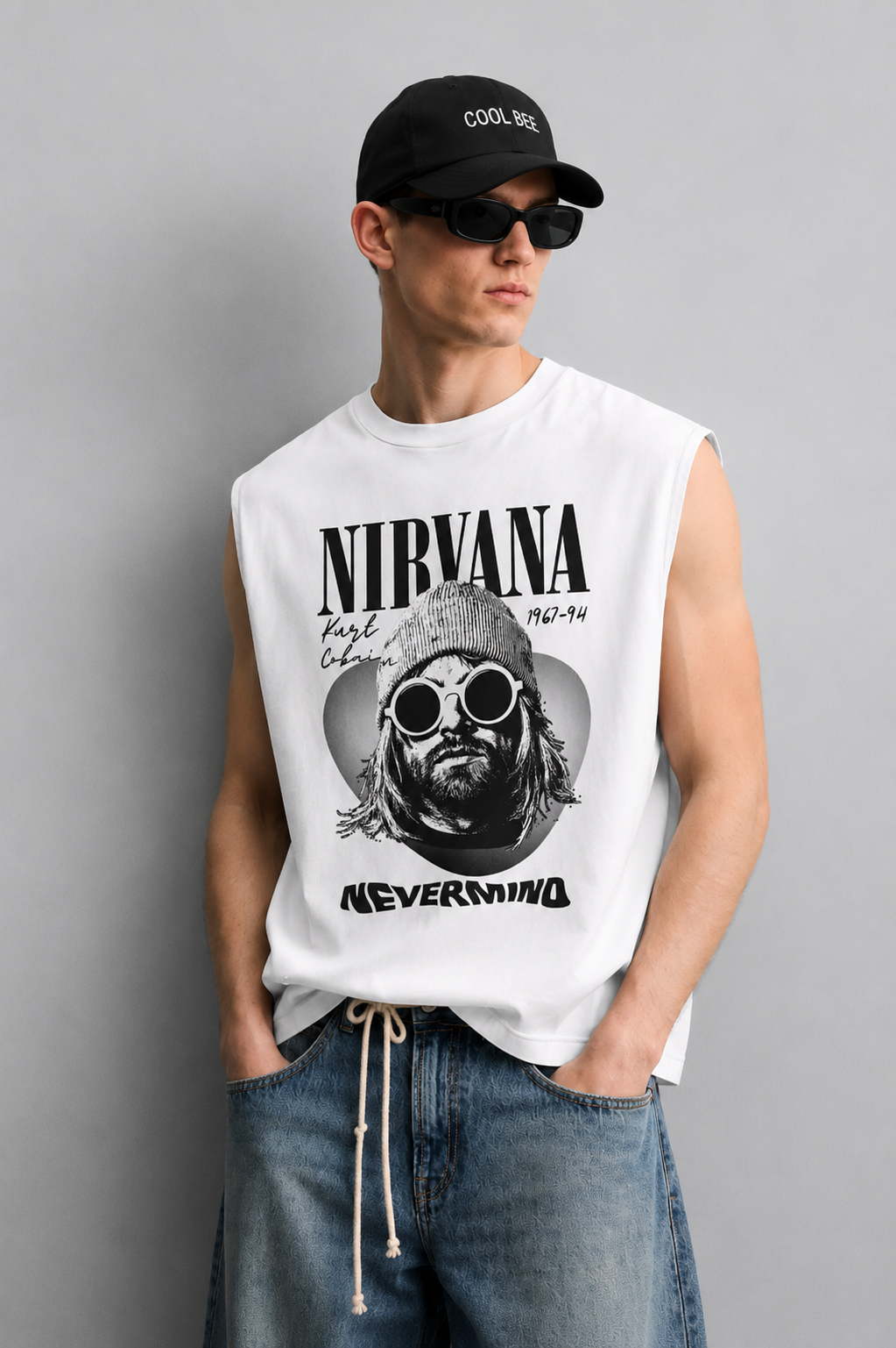 White tank top with bold serif band-style lettering, a halftone portrait of a musician in a beanie and round sunglasses inside a guitar-pick silhouette, and large album-title-style text at the bottom.