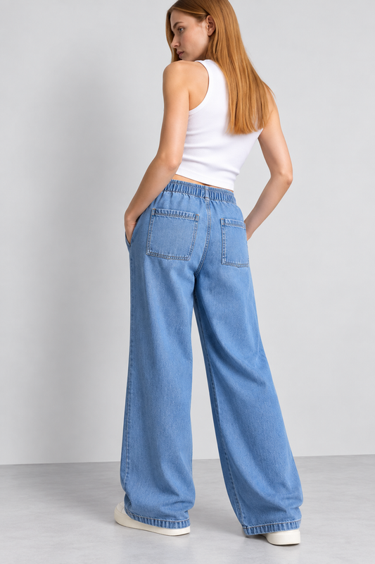 Woman wearing Cool Bee mid blue cotton denim wide leg joggers with drawstring waist