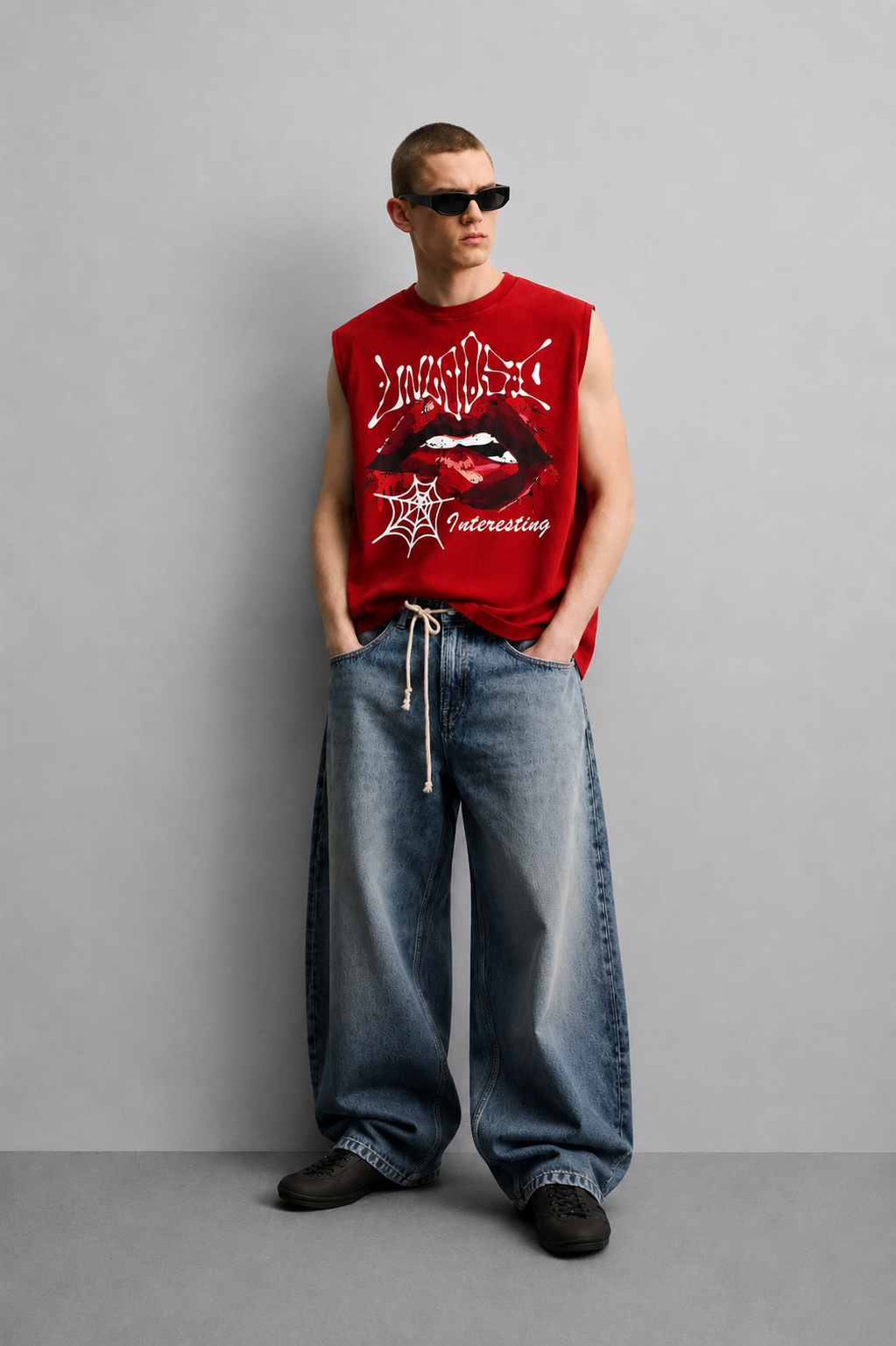 Red tank top with dripping graffiti-style 'Unholy' lettering, a close-up illustrated graphic of lips with a piercing detail, and a small spiderweb icon with script text.