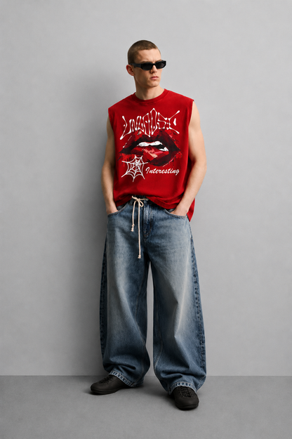 Red tank top with dripping graffiti-style 'Unholy' lettering, a close-up illustrated graphic of lips with a piercing detail, and a small spiderweb icon with script text.