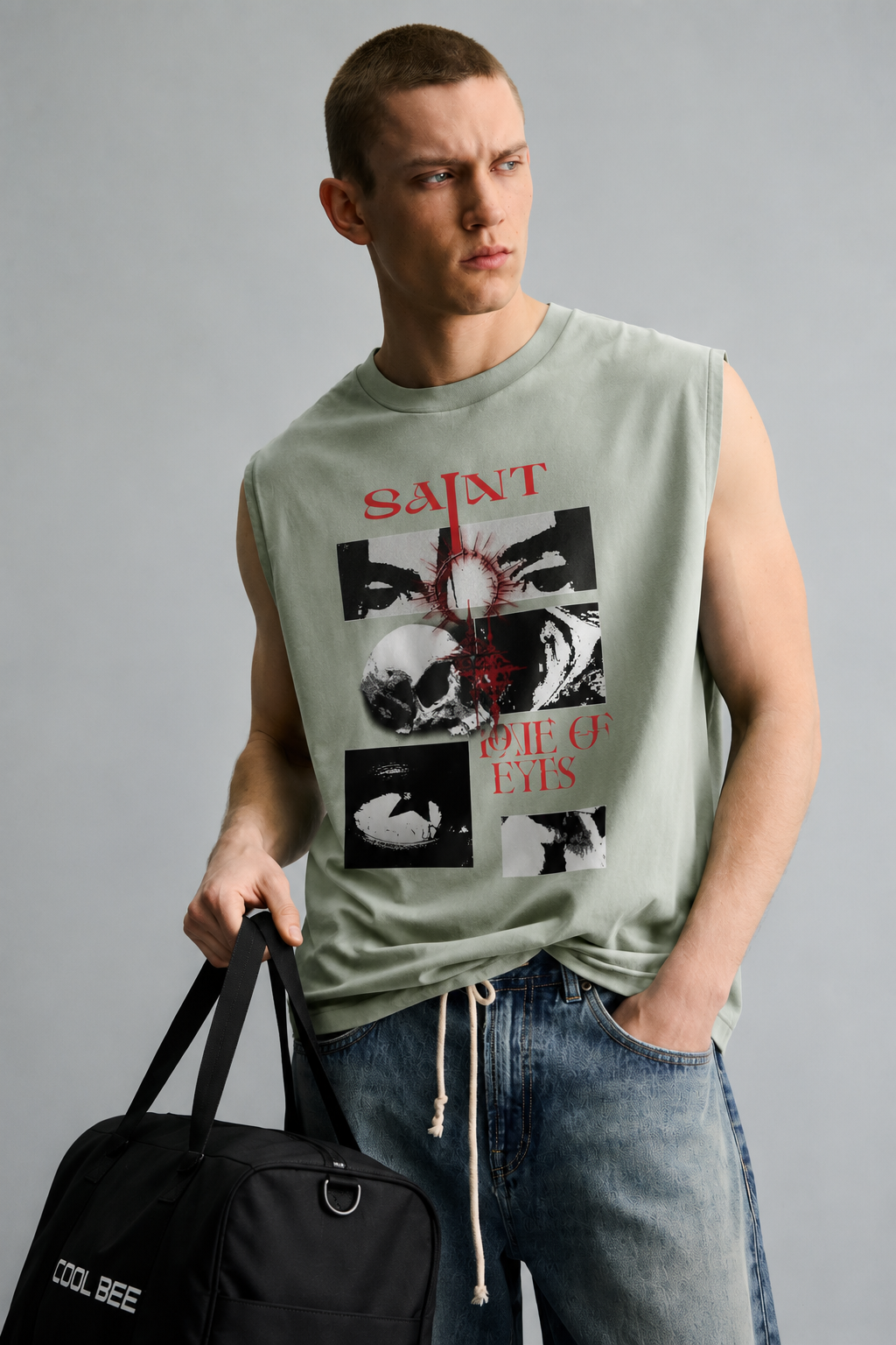 Sage green tank top with red 'Saint' lettering above a black-and-white photo grid featuring a radiant eye, a skull, a close-up face, and an abstract textured panel.