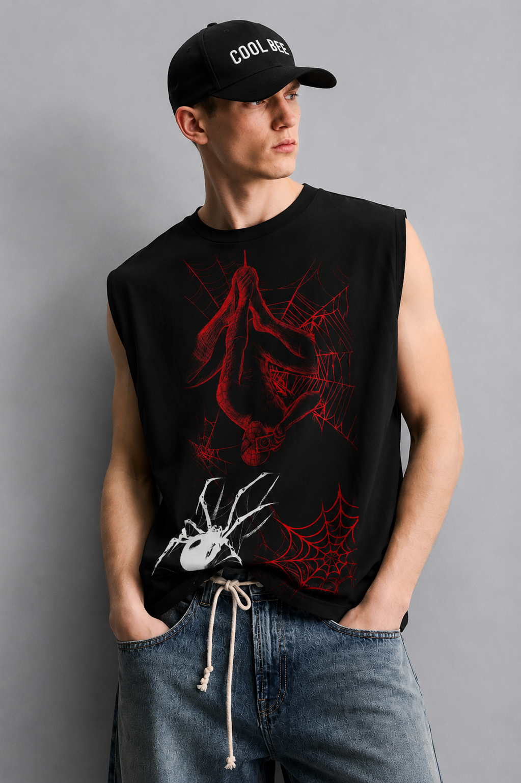 Black tank top with a red-lined illustration of a masked superhero figure hanging upside down in a web, alongside a white spider graphic and red spiderweb accents.