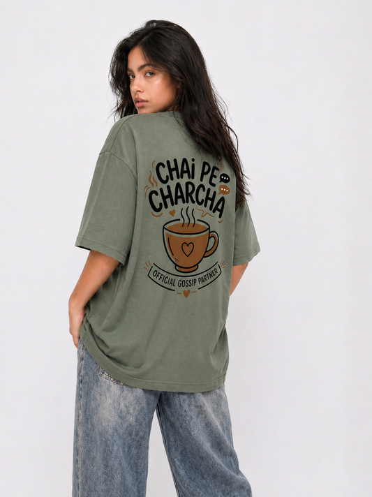 Person wearing a green t-shirt with 'Chai Pe Charcha' text and graphic on a white background