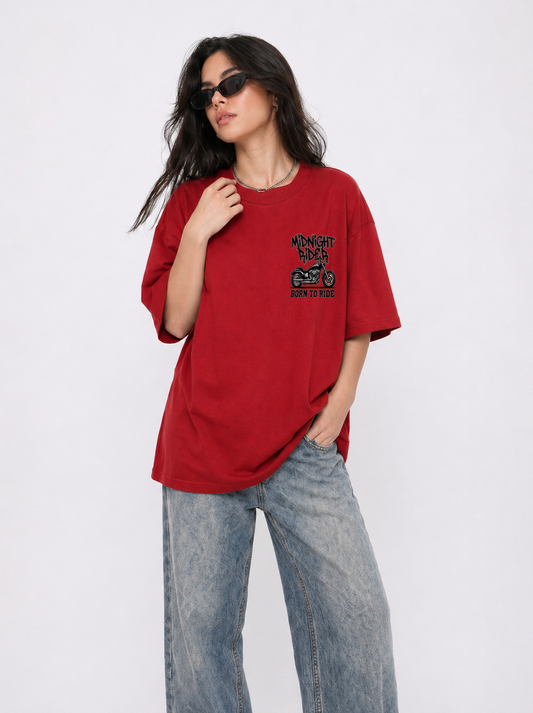 Woman wearing a red t-shirt with a graphic design and blue jeans on a white background