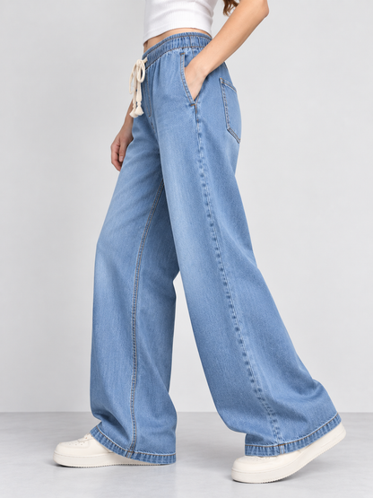 Cool Bee Cotton Denim Wide Leg Joggers in Mid Blue - side angle view with hand in pocket